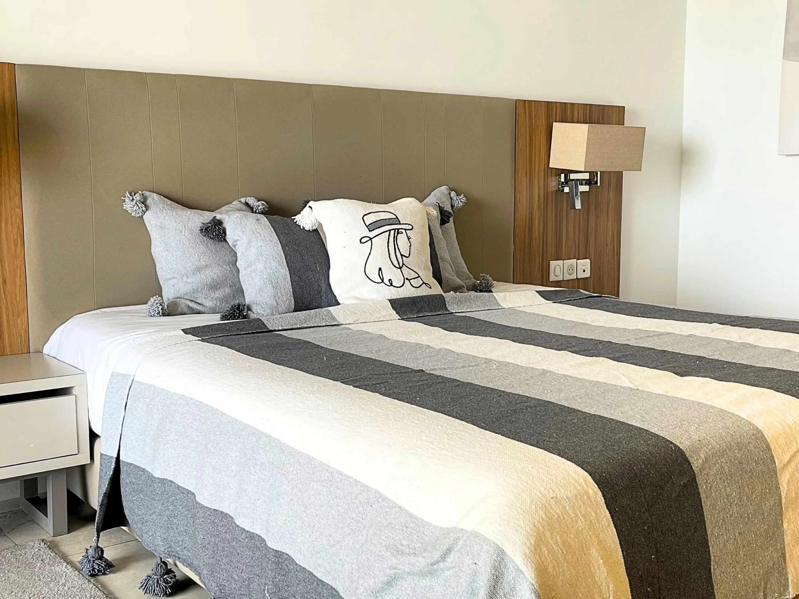 Plaid gris et blanc placé sur un canapé pour décoration et confort